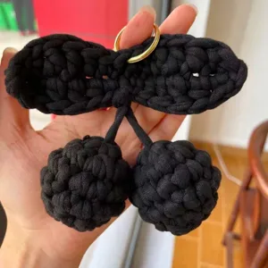 Dettaglio di un portachiavi a ciliegia nero fatto a mano con un bell'anello dorato