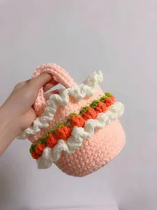 Detail view of cute handmade pink crochet tote basket with strawberry ruffle design