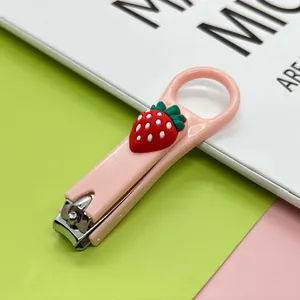 Nahaufnahme eines niedlichen rosa Cartoon-Nagelknipsers mit einem 3D-Erdbeer-Anhänger