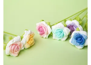 Primer plano detallado de rosas tejidas a mano en crochet sobre fondo verde claro