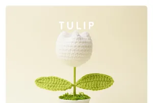 Κοντινό πλάνο χειροποίητης λευκής πλεκτής τουλίπας σε ένα μικρό γλαστράκι με φυτό.