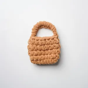 Vista detallada de una minibolsa para auriculares de hilo grueso hecha a mano en color camel.