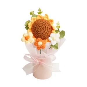 Handgemaakt gehaakt boeket zonnebloemen en madeliefjes in een roze geschenkpotje.
