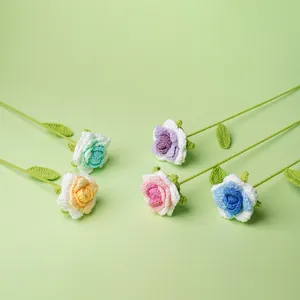 Set de cinco rosas de ganchillo hechas a mano en colores vivos sobre fondo verde claro.