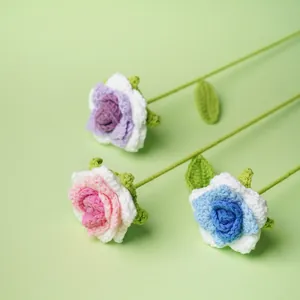 Rosas de ganchillo hechas a mano en tres colores pastel sobre fondo verde decor