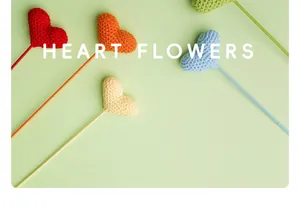 Detalle de cerca de flores con forma de corazón tejidas a mano y ganchillo en palos