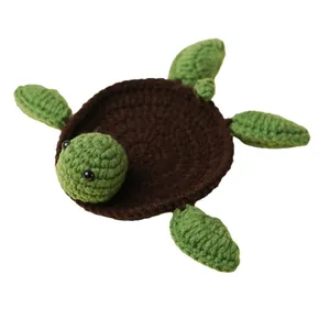 Handmade crochet turtle coaster with brown shell and green flippers for home decor