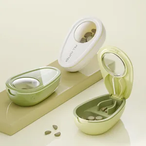 Tragbarer Tablettenteiler und Pillendose in Avocadoform in Weiß und Grün auf einem Ständer