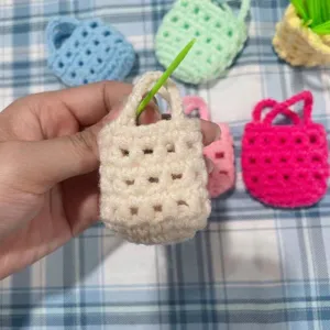 Nahaufnahme eines handgemachten Häkel-Mini-Taschenanhängers in Creme