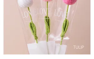 Close-up of handmade crocheted tulips in white and pink shades with gift packaging