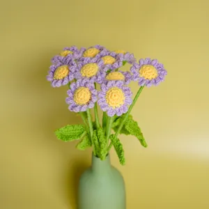 Handgehäkelter violetter Gänseblümchenstrauß aus Garn in einer grünen Vase Deko