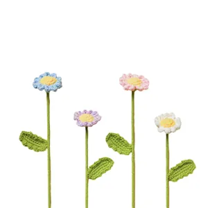 Handgefertigte Häkel-Gänseblümchen aus Garn in Pastellfarben auf weißem Hintergrund.