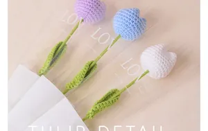 Close-up of handmade crocheted tulips in purple, blue, and white packaging