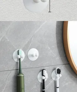 Detail of white suction cup toothbrush holders mounted on a gray marble bathroom wall