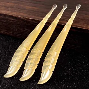 Three translucent yellow feather-shaped ear picks for gentle and safe ear cleaning