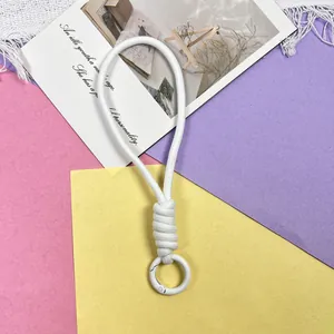Detailweergave van de witte verdikte gevlochten knoop en metalen ring aan het polskoord.