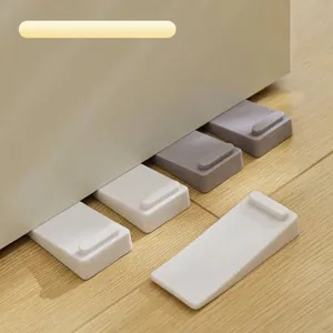 Close-up detail of non-slip rubber door stopper wedges placed under a door on wood floor