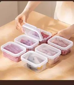 Detail showing six plastic food containers used for storing raw meat on a table.