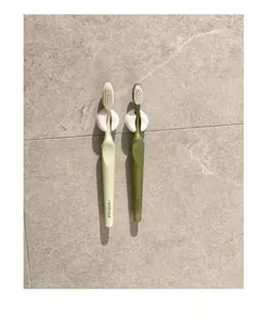 Close-up of white suction cup toothbrush holders mounted on a tiled bathroom wall
