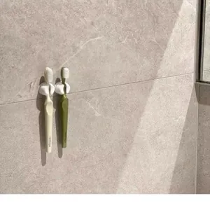 Wall-mounted suction cup toothbrush holders showing secure grip on modern bathroom tiles.