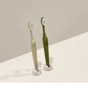 Detail view of white suction cup toothbrush holders on a minimalist bathroom vanity