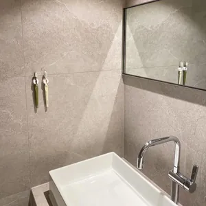 Suction cup toothbrush holders mounted on a textured grey stone bathroom wall scene