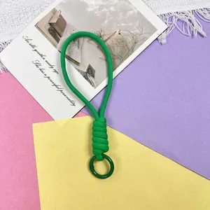 Gedetailleerde weergave van de groene gevlochten telefoonpolsband met de bevestigingsring