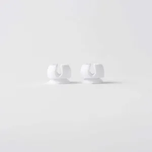 Detailed view of two white silicone suction cup toothbrush holders for bathroom