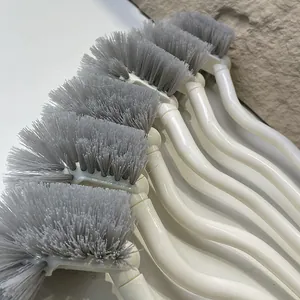 Detail view showing gray bristles and white curved handles of multiple toilet brushes
