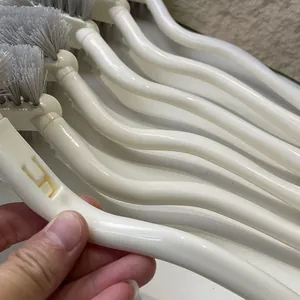 Detailed close-up of the long ergonomic curved handle of a toilet cleaning brush