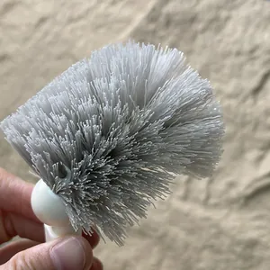 Close-up of dense grey bristles on a Japanese-style bathroom toilet cleaning brush