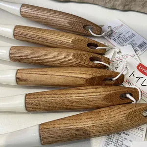 Detailed close-up showing the smooth natural wood handles of a Japanese style toilet brush