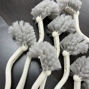 Multiple long-handled Japanese toilet brushes with grey bristles on dark background