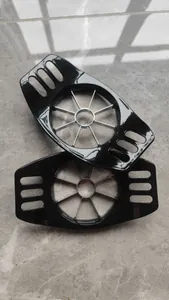 Detail shot of two black apple slicers with stainless steel blades on a grey background.