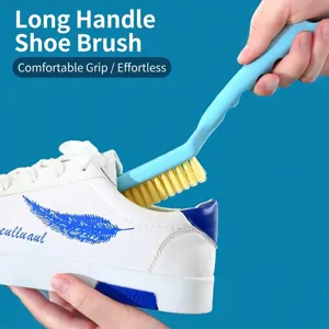 Blue long-handled shoe cleaning brush with yellow bristles washing white sneakers