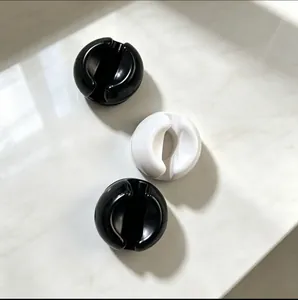 Macro view of minimalist black and white suction cup toothbrush holders for bathroom