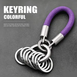 Close-up of purple braided rope keychain with multiple silver rings on a grey background
