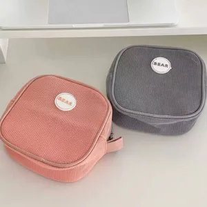 Detailed view of two mesh square portable makeup bags in pink and grey colors for travel use