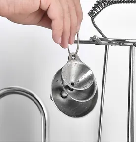 Primer plano de tres mini embudos encajables de acero inoxidable colgados de un anillo