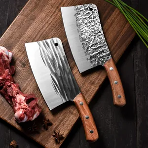 Heavy duty forged meat cleavers with unique textured blades on a wooden cutting board