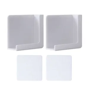 Support mural blanc minimaliste pour charger le téléphone avec des tampons adhésifs.