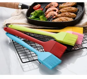 Pinceaux de cuisine en silicone colorés sur une grille pour le barbecue de fête.