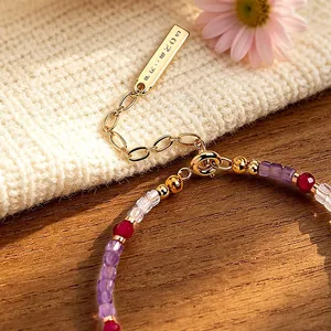 Detail view of high-end faceted amethyst and tourmaline crystal bracelet with gold clasp