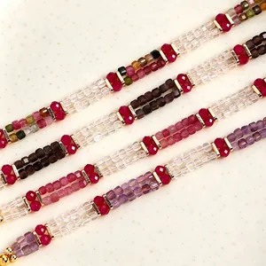 Macro detail view of faceted square crystal beads on multiple colorful handmade bracelets