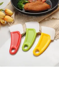 Dettaglio di raschietti da cucina in silicone rosso, verde e giallo per pulire pentole