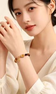Elegant natural yellow tiger's eye beaded heart charm bracelet shown on female model arm