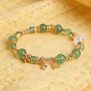 Close-up of elegant green aventurine beads and gold-plated crystal charm bracelet