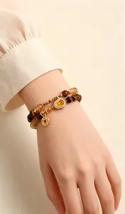 Detail shot of a double-strand bracelet with tiger eye beads and golden gourd charm