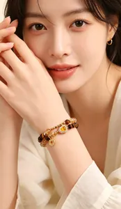 Close-up of double-wrap tiger eye and yellow crystal bracelet on female model