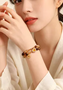 Close-up of double-layer tiger eye and yellow crystal bracelet on female wrist